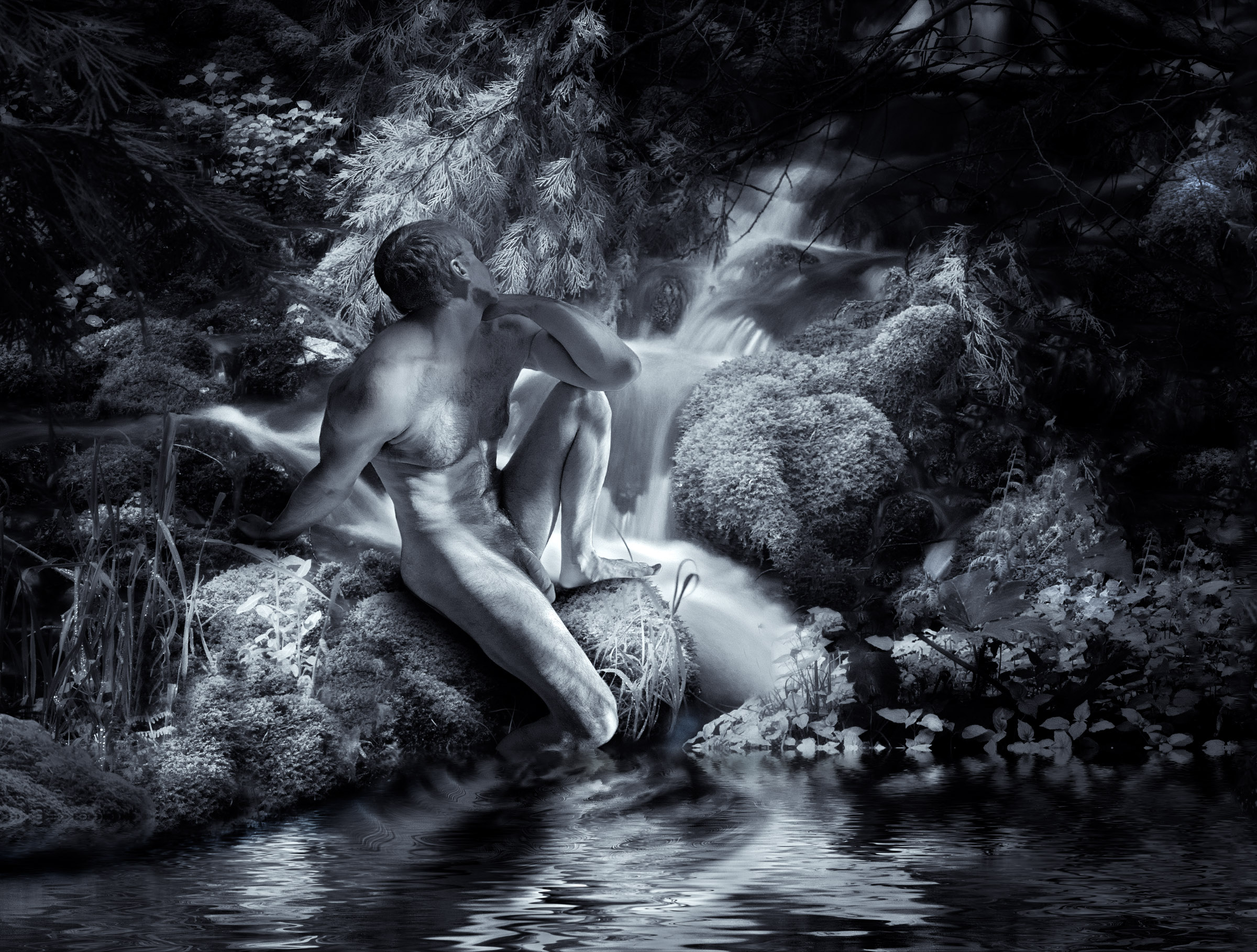 Black-and-white infrared photograph of a nude male figure seated on a mossy rock beside a small forest waterfall and pond. He is shown in profile with one knee raised, his head turned toward the falling water. Pale, luminous foliage surrounds him, while the curving waterfall and its reflection echo the lines of his body against deep woodland shadows.